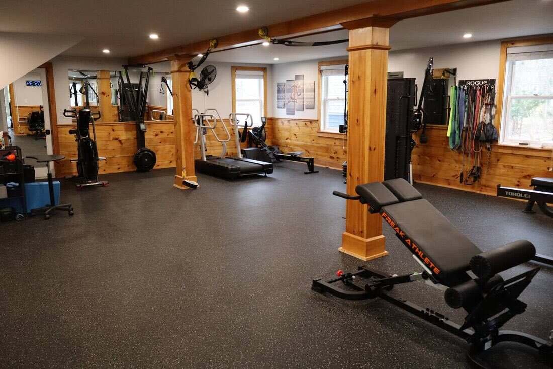 Cardio and accessory room with curved treadmill, rower, resistance bands, and bench