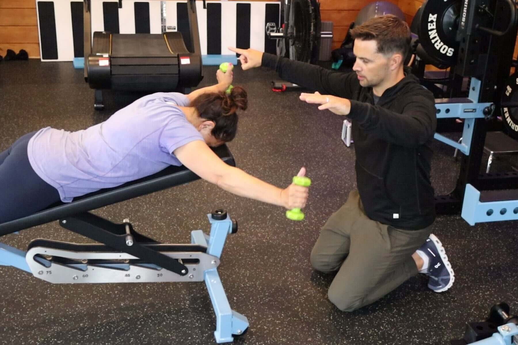 Dr. Shawn Sprague coaching a client through a dumbbell fly on the incline bench